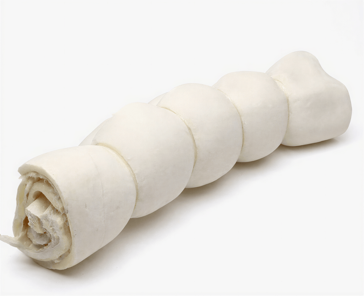 One white cylindrical rolled beef cheek dog chew with a segmented texture on a plain white background.