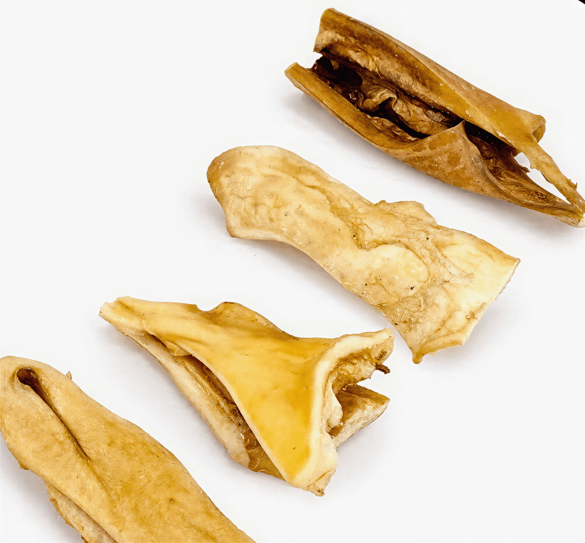 Four tan and brown textured beef cheek slices arranged diagonally on a white background.