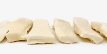 Seven cream-colored, thick rectangular beef cheek slices arranged in a row on a white background.