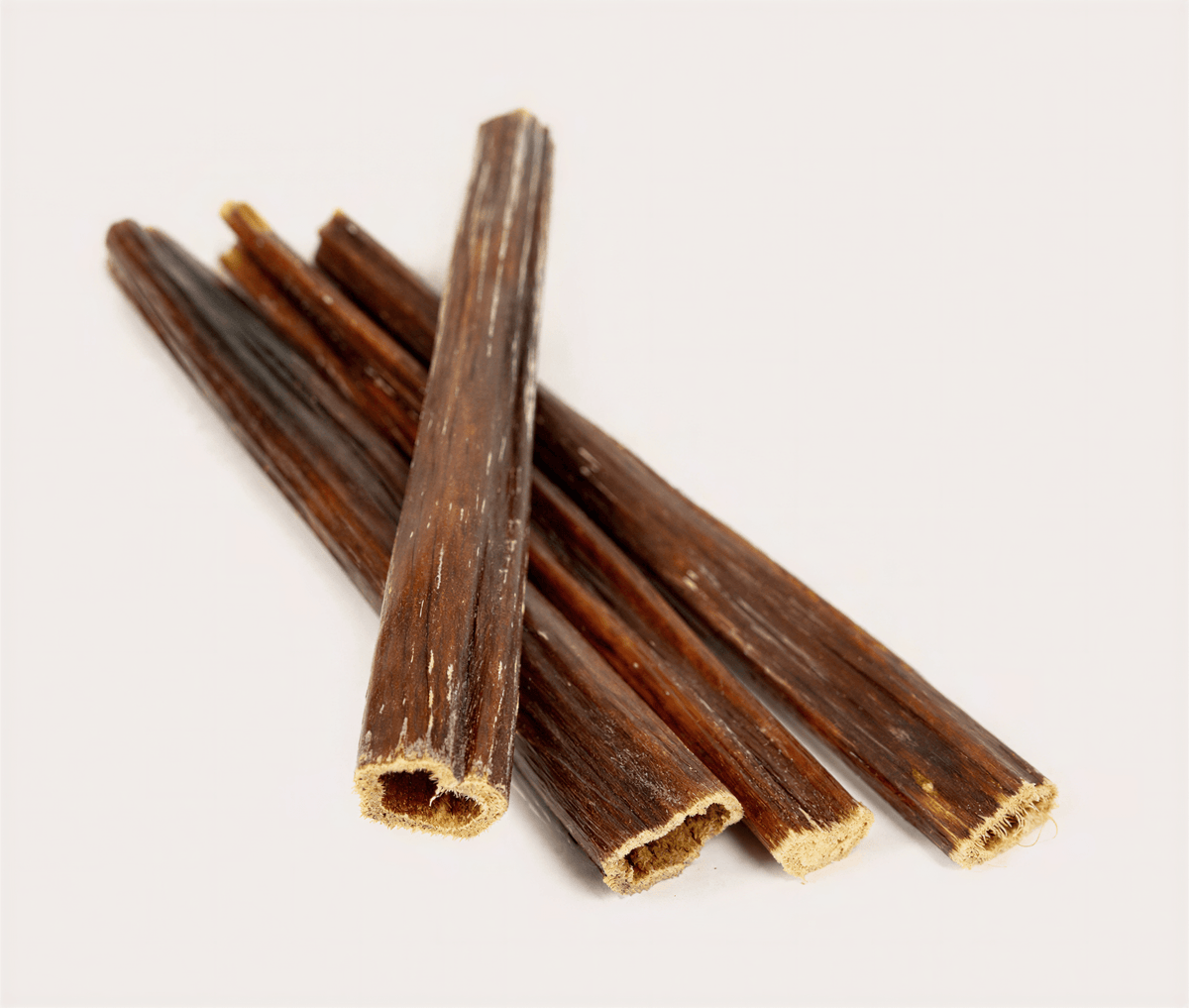 Five long, dark brown textured beef gullet sticks stacked together on a plain white background.