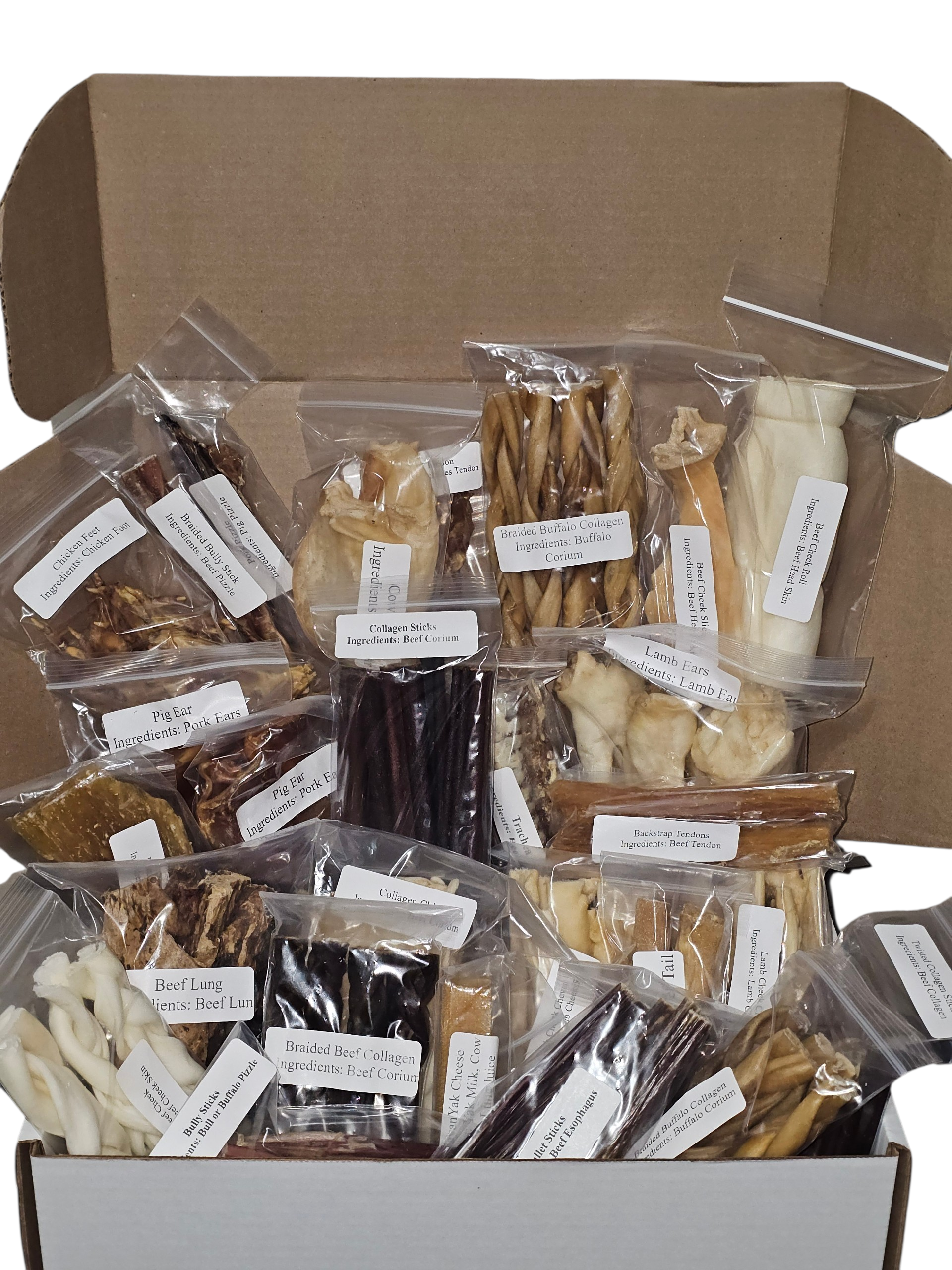 Assorted brown and tan dog chews in clear plastic bags inside a cardboard Ultimate Chomper Treat Box.